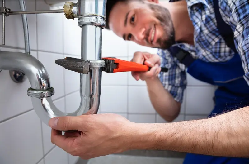 Plumber Repairing Sink With Adjustable Wrench