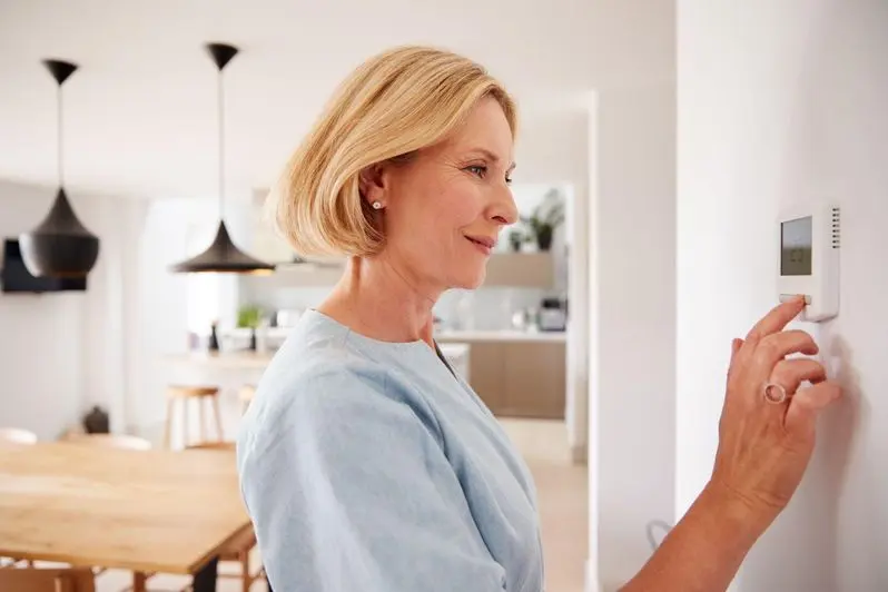 Woman turning on her AC in a home