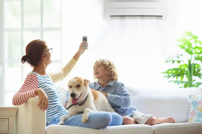 Family on the couch with their dog enjoying the AC inside their home