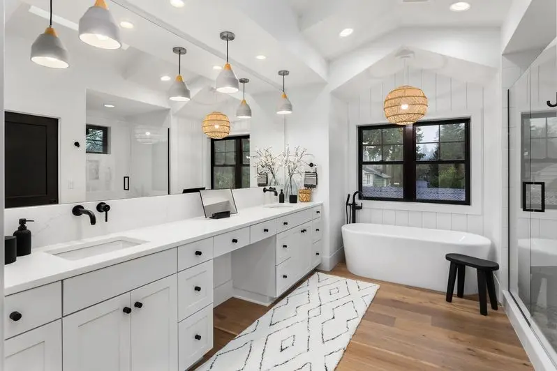 Beautiful bathroom in luxury home with double vanity, bathtub, mirror, sinks, shower, and hardwood floor