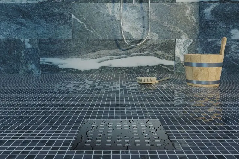 water drops on metal gutter of shower tray in valser quartzite stone