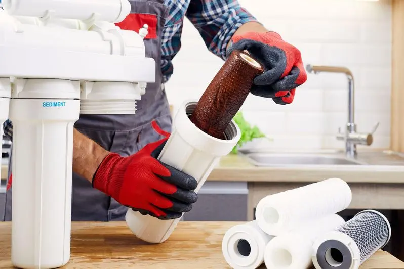 Plumber changing a dirty reverse osmosis filter