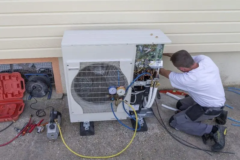 technician working on a heat pump outside