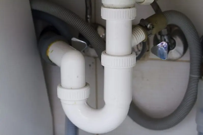 sink with flexible tube over flow connect in white wall