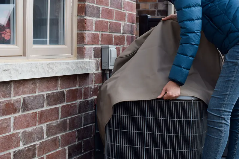 Woman covering her outside AC unit to protect it from damages
