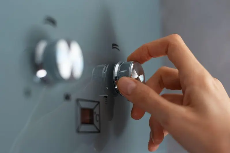 Close-up of female hand adjusting temperature of water heater.