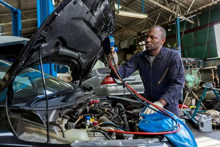 Auto mechanic monitor to check and fixed car air conditioner system in car garage.