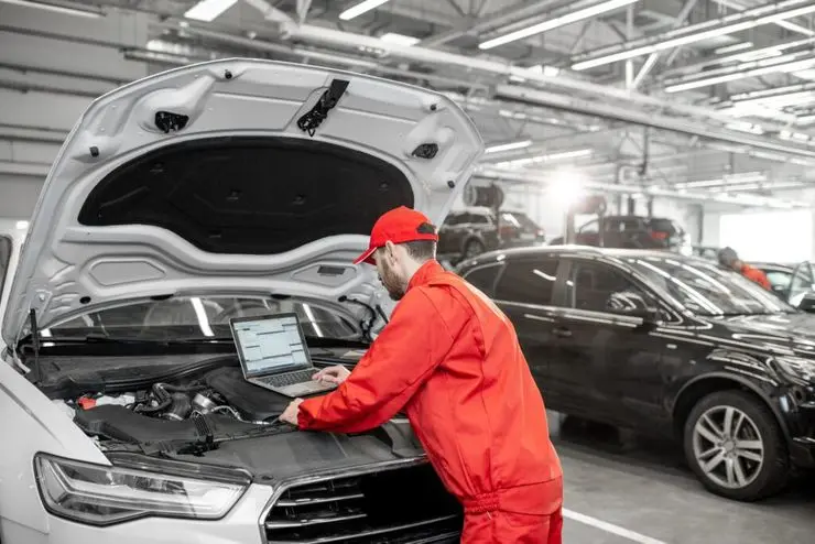 Auto mechanics doing diagnostics with laptop