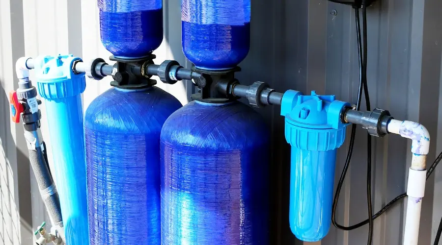 Water filtration system with blue tanks and components for removing contaminants from household water supplies.
