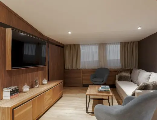 Dnevni boravak apartmana hotela Grand Kopaonik sa velikim TV ekranom na drvenoj zidnoj oblozi i udobnim kaučem