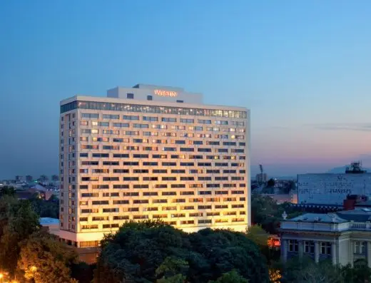 Noćni pogled na fasadu Hotel Westin Zagreb sa osvetljenim prozorima, natpisom Westin na vrhu i gradskim siluetom u pozadini