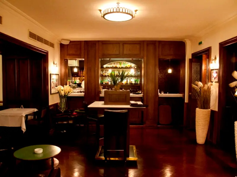 Bar u Restoranu Klub književnika sa drvenom lamperijom, art deko plafonskom lampom i intimnom atmosferom