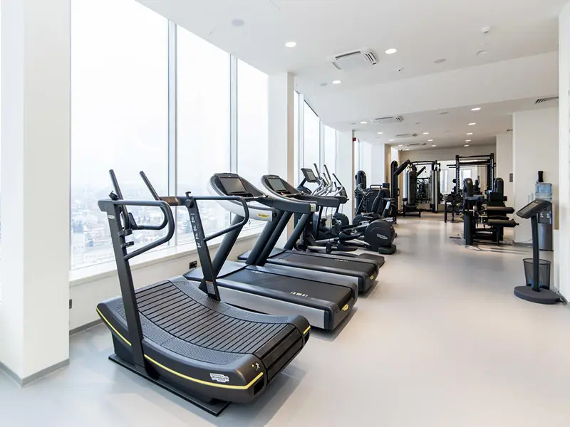 Fitnes centar u Hotel Sheraton Novi Sad sa Technogym trakama za trčanje, spravama za vežbanje i velikim panoramskim prozorima sa pogledom na grad