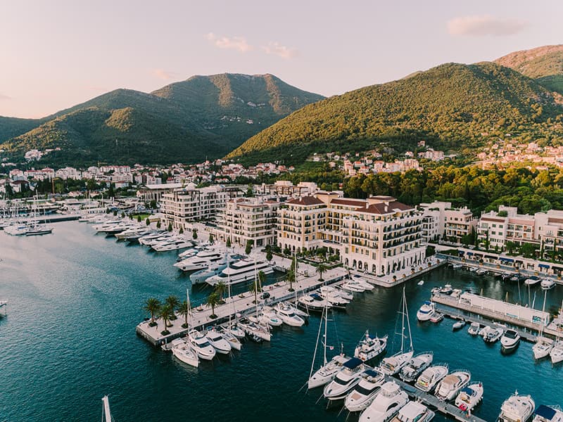 Aerial pogled na Regent Porto Montenegro sa marinom punom jahti, Bokokokotorskim zalivom i zelenim planinama u pozadini