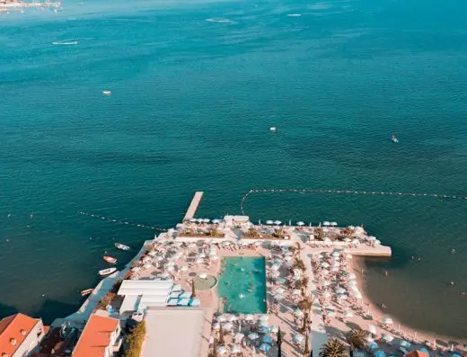 Aerijalni pogled na Palmon Bay Hotel & Spa beach club sa bazenom, pontonom, suncobranima, ležaljkama i tirkiznim morem