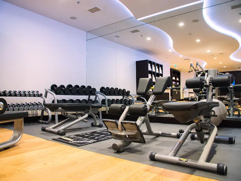Fitnes centar u hotelu Courtyard Belgrade City Center sa bučicama, spravama za vežbanje, velikim ogledalima, LED osvetljenjem na plafonu i drvenim podom