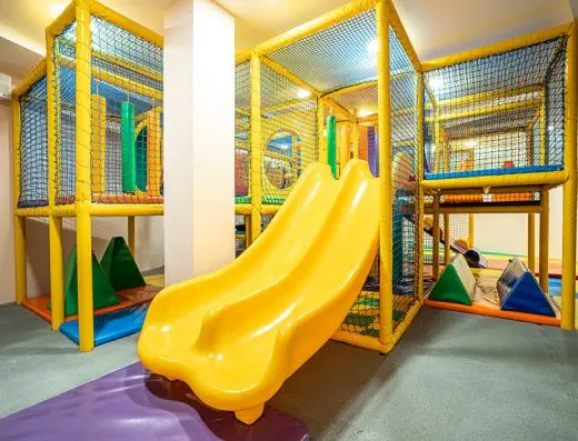 Dečja igraonica u Hotel Tonanti sa žutim dvostrukim toboganom, šarenim tunelima, mrežama za penjanje i mekim strunjačama