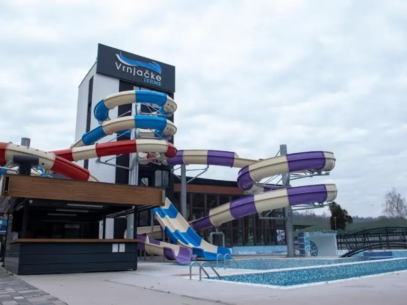 Akva park u Hotel Vrnjačke Terme sa šarenim tobogan stazama u plavoj, crvenoj i ljubičastoj boji, spoljašnjim bazenom i natpisom hotela