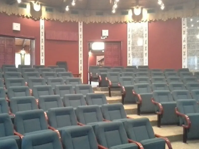 Bioskopska sala u Kongresnom centru Velika terasa sa plavim foteljama, bordo zidovima i dekorativnim stubovima
