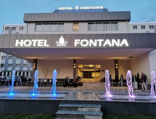Noćni eksterijer Hotel Fontana, Vrnjačka Banja sa osvetljenim ulazom, dekorativnim fontanama u plavoj i ljubičastoj boji i natpisom hotela