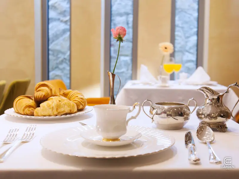 Doručak u restoranu Garden Spa Boutique Hotel sa kroasanima, belim porcelanskim servisom, srebrnim čajnikom i čašom soka od pomorandže