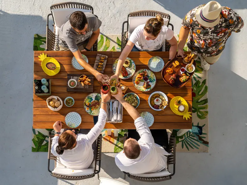 Grupalna večera u Key West Beach & Restaurant sa šarenim tanjirima, tropskim podmetačima i nazdravljanjem