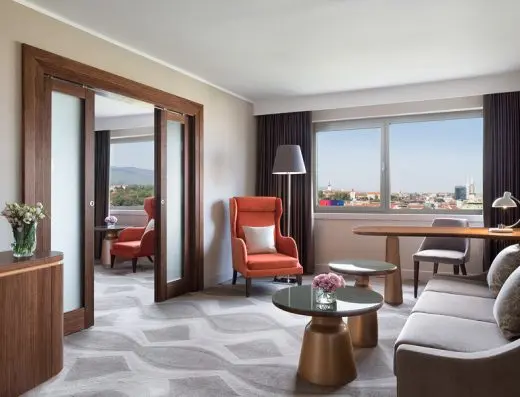 Apartman u Hotel Westin Zagreb sa dnevnom sobom, narandžastom foteljom, bronzanim stočićima, kliznim ogledalnim vratima i pogledom na grad