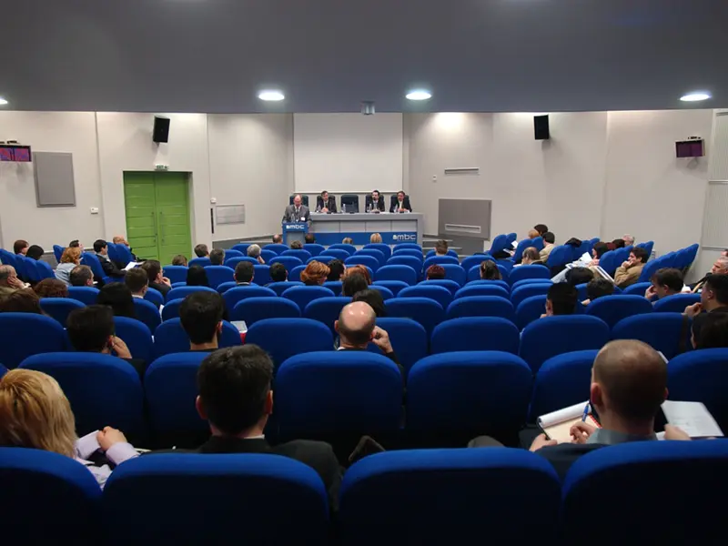 Pun auditorijum u ERA Group Skopje Fair Congress Center sa pogledom iz zadnjih redova na paneliste za MBC stolom i plave fotelje