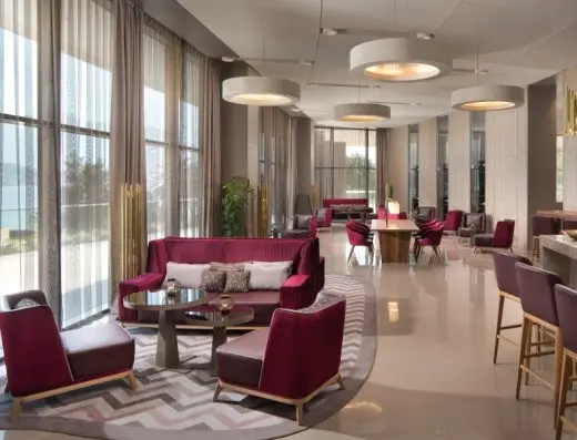 Lobi bar u hotelu Sheraton Dubrovnik Riviera Hotel sa bordo baršunastim foteljama i kaučevima, okruglim plafonskim svetlima i velikim prozorima