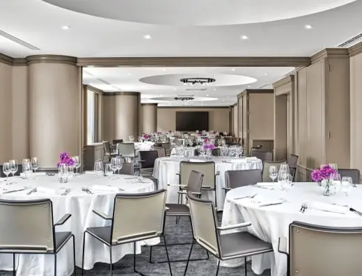 Banket sala u Sheraton Zagreb Hotelu sa okruglim stolovima prekrivenim belim stolnjacima, čašama i ljubičastim cvetnim aranžmanima