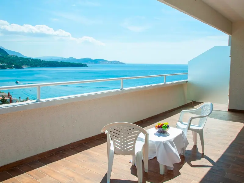 Balkon sobe u Sato Hotel Conference & Spa Resort hotelu sa stolom, voćem i panoramskim pogledom na Jadransko more i planine