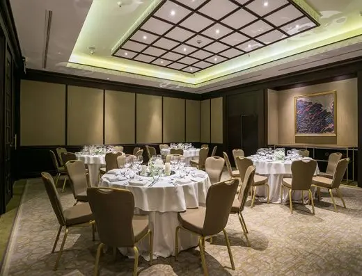 Banket sala u Hyatt Regency Beograd sa okruglim stolovima postavljenim za svečanu večeru, belim stolnjacima, cvećem i apstraktnom slikom