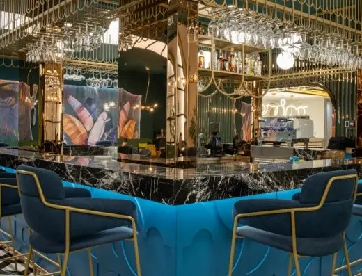 Bar u Hotel Calisi sa crnim mermernim šankom, plavim barskim stolicama sa zlatnim okvirom i visećim čašama