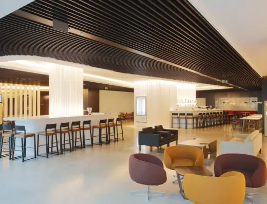 Bar u lobiju Crowne Plaza Beograd hotela sa visokim stolicama i modernim drvenim plafonskim oblogama
