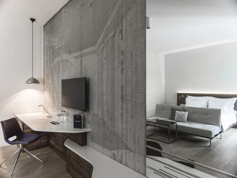 Apartman u hotelu Radisson Collection Hotel Old Mill Belgrade sa betonskom teksturalnom pregradom, televizorom, radnim stolom, krevetom i kaučem u loft stilu