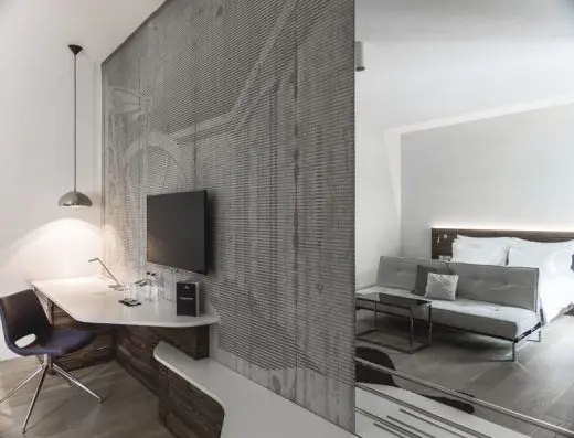 Apartman u hotelu Radisson Collection Hotel Old Mill Belgrade sa betonskom teksturalnom pregradom, televizorom, radnim stolom, krevetom i kaučem u loft stilu