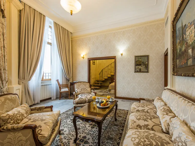 Salon apartmana u Hotel Moskva sa klasičnim foteljama, damast tapetom, uljenim slikama i pogledom na stepenište