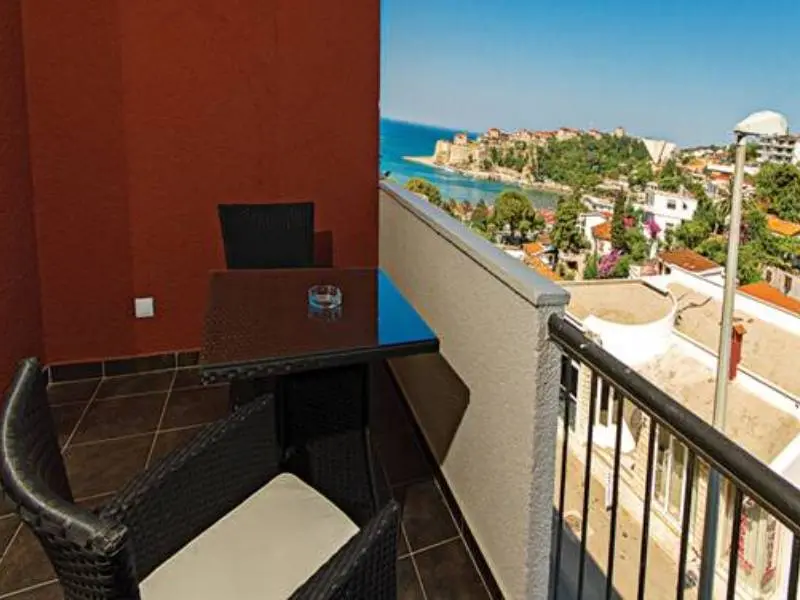 Balkon sobe u Hotel Mediteran Ulcinj sa ratanskim stolom i stolicama, pogledom na more, Stari grad Ulcinj i okolne krovove