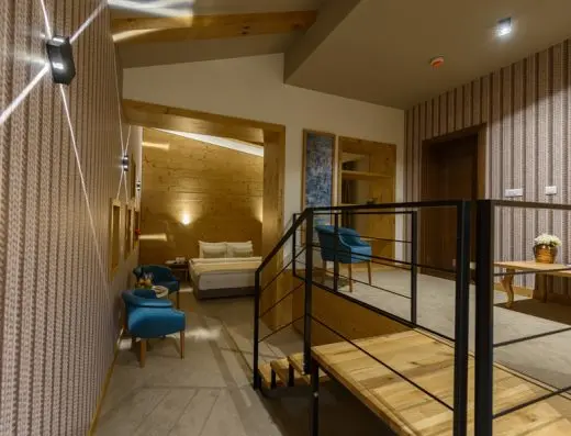 Dupleks suite u Hotel Sunce sa drvenim stepenicama, metalnom ogradom, drvenom oblogom, krevetom na donjem nivou i tirkiznim foteljama