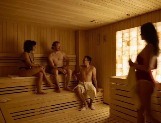 Finska sauna u Hotel Zlatibor Mona sa grupom gostiju na drvenim klupama, osvetljenim zidom od himalajske soli i toplim ambijentalnim osvetljenjem