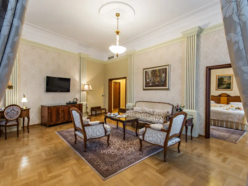Dnevna soba apartmana u Hotel Moskva sa parketom, persijskim tepihom, klasičnim foteljama, slikama i lusterom