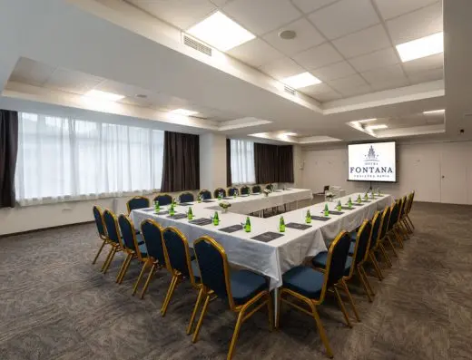 Konferencijska sala u Hotel Fontana, Vrnjačka Banja sa stolovima u U-rasporedu, belim stolnjacima, plavim stolicama i projektorskim platnom sa logom