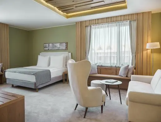 Soba u Gorski Hotel & Spa sa zelenim zidovima i belom foteljom u planinskom stilu