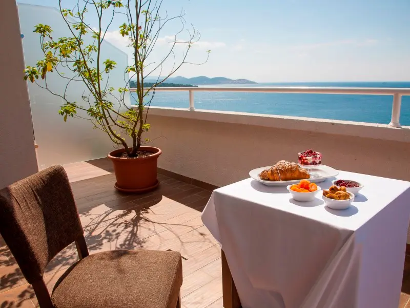 Doručak na balkonu Sato Hotel Conference & Spa Resort hotela sa kroasanom, voćem i pogledom na Jadransko more i ostrva