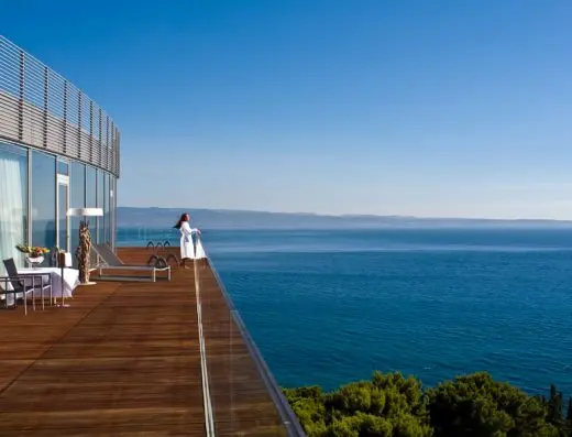 Terasa suite sobe u Radisson Blu Resort Split sa drvenom palubom, ležaljkama, belom foteljom i panoramskim pogledom na Jadransko more