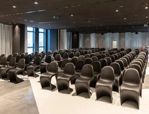 Konferencijska sala u hotelu Zonar Zagreb sa crnim Panton stolicama u teatar rasporedu, modernim dizajnom, belim podom i sivim zavesama