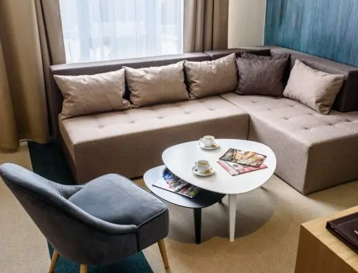 Dnevna soba apartmana u hotelu Kraljevi Čardaci Spa sa ugaonim kaučem, okruglim stočićem za kafu, sivom foteljom i tirkiznim detaljima