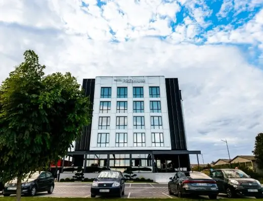 Fasada Premium Hotel danju sa modernom belom i crnom arhitekturom, natpisom Premium, staklenim prozorima, parkingom i zelenim drvoredima