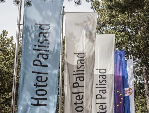 Zastave Hotel Palisad sa natpisima Relax, Leisure i Congress meÄ‘u borovim drveÄ‡em