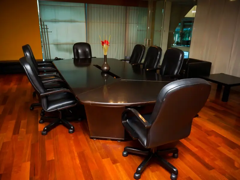 Boardroom soba u Radon Plaza Hotel sa tamnim konferencijskim stolom, crnim kožnim stolicama, parketom i staklenim pregradama